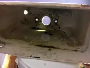 Inside of a toilet tank showing the flush valve opening