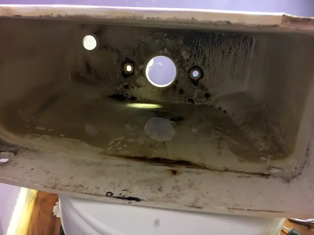 Inside of a toilet tank showing the flush valve opening