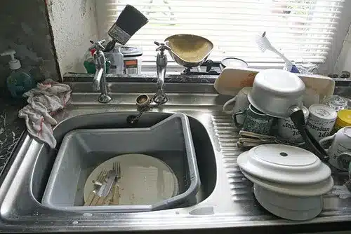 Kitchen sink filled with dirty dishes