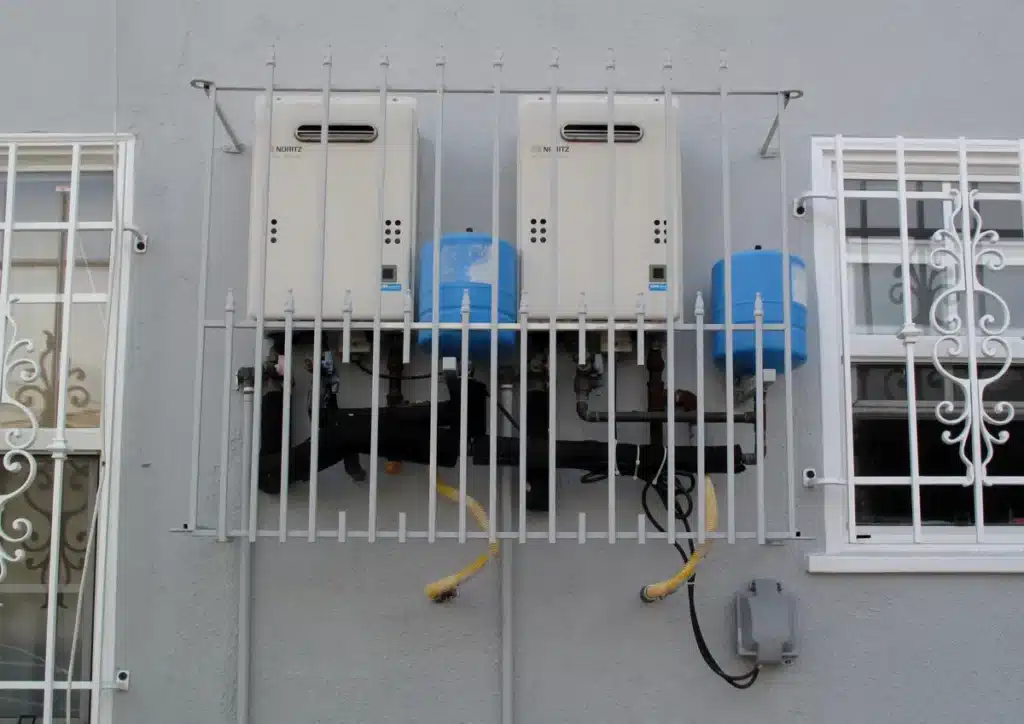 Two tankless water heaters mounted on an outside wall