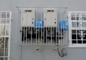 Two tankless water heaters mounted on an outside wall