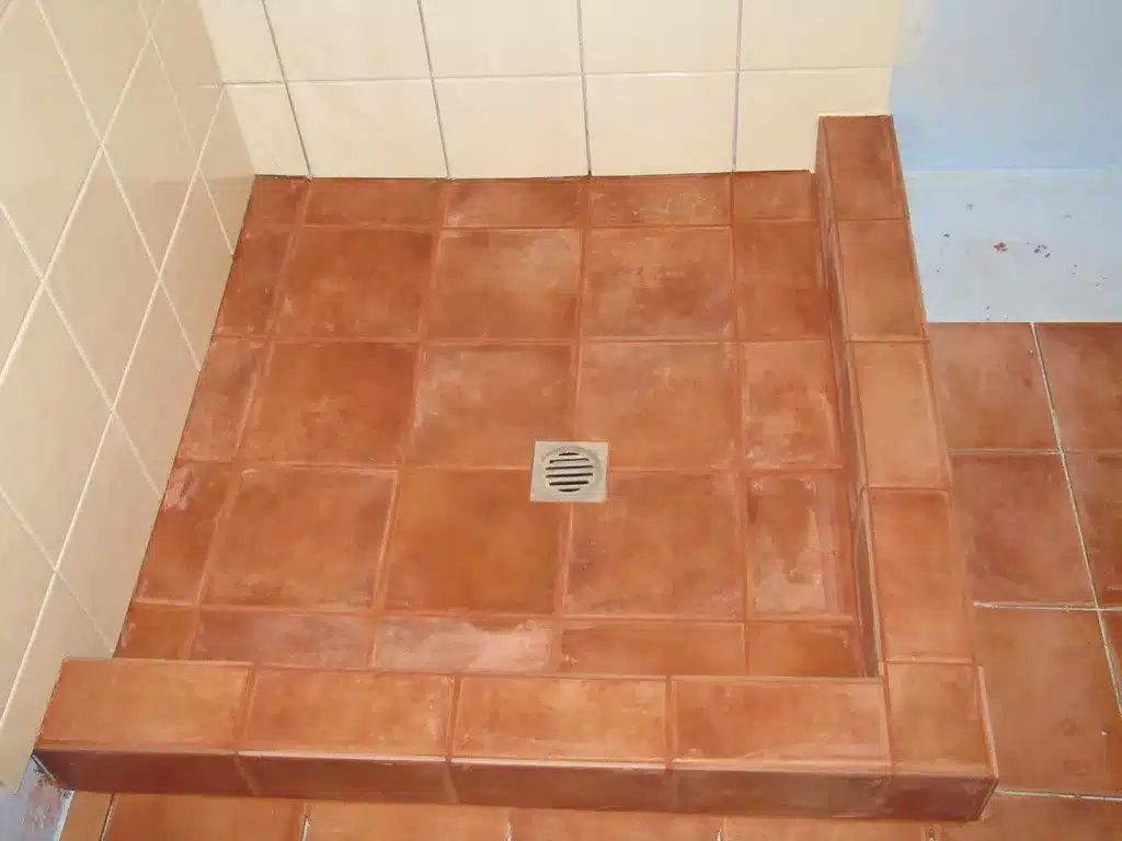 Tiled shower pan floor sloping to a center drain