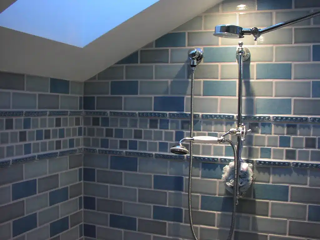 Tiled shower with a handheld showerhead on a slide bar