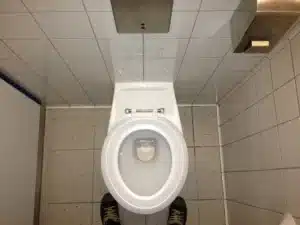 White toilet with the lid open in a tiled bathroom