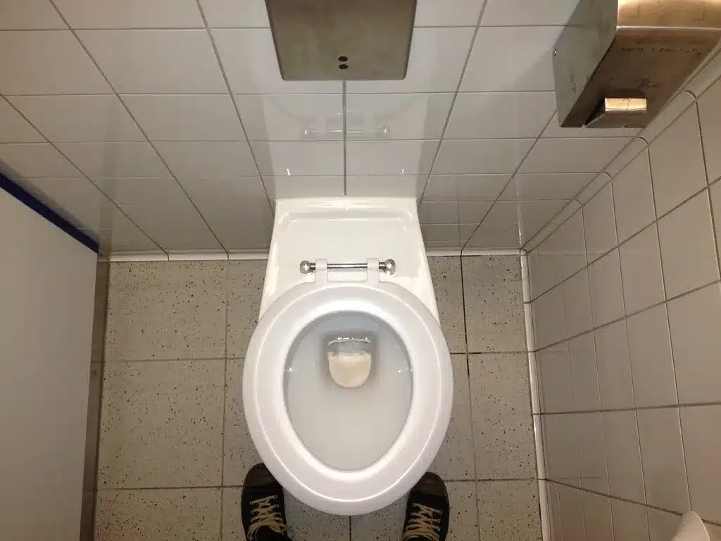 White toilet with the lid open in a tiled bathroom